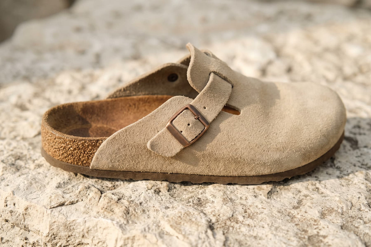 Close up of a sand suede clog showing the contoured cork footbed and plain buckle