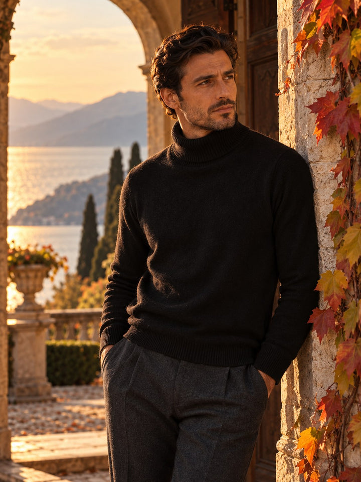 Man in a black cashmere rollneck in a villa doorway at sunset