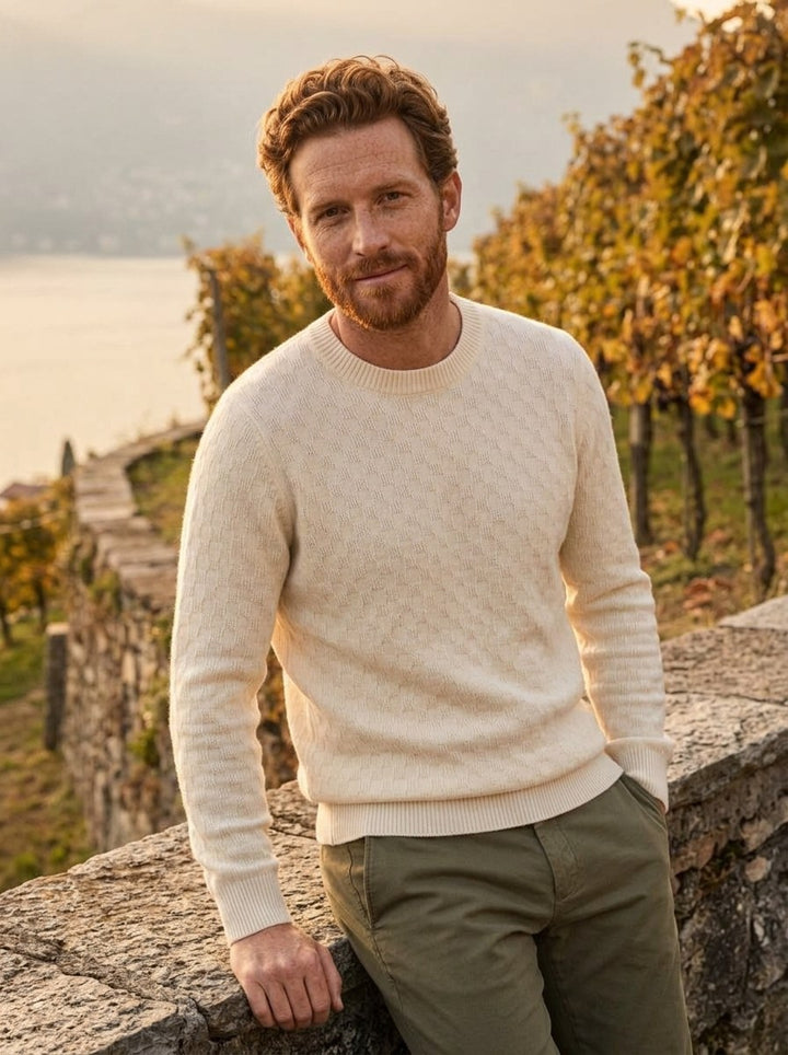 Man in a cream textured cashmere crewneck at a vineyard above the lake